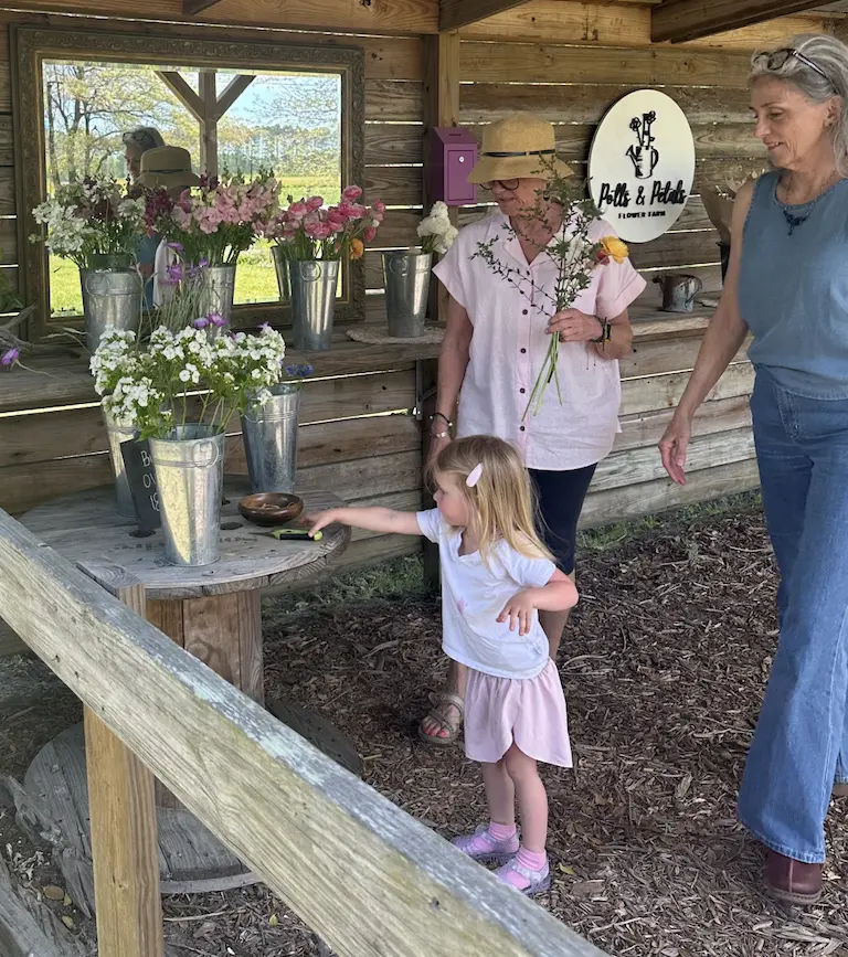 customers browsing the selection of local flowers at a road side flower stand